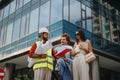 Architects and engineers discussing project design outdoors. Analyzing blueprint, inspecting site, creating sustainable Royalty Free Stock Photo