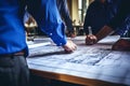 Architects and engineers discussing at table. Person& x27;s engineer hand drawing plan on blue print. teamwork and Royalty Free Stock Photo