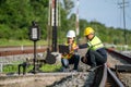 Architects and engineers sit and use laptops to point out railroad tracks where repairs to the railroad switch construction Royalty Free Stock Photo