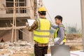 Architects and engineers working together sketching building plans and discussing at construction site wearing uniforms Royalty Free Stock Photo