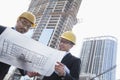 Architects looking at blueprint on construction site, Beijing Royalty Free Stock Photo