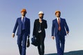 Architects with strict faces in suits, white and orange helmets