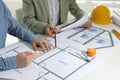 Architects working with construction drawings at table in office, closeup Royalty Free Stock Photo