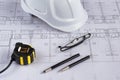 Architects workplace - architectural blueprints with measuring tape, safety helmet, glasses and propelling pencil on table. Top vi Royalty Free Stock Photo