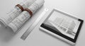 Architectural blueprints and digital tablet displaying a building design on white surface Royalty Free Stock Photo