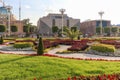 Architectural buildings in the park. Green lawn with flowers and green bushes.