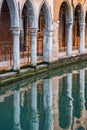 Architectural detail with the arch columns reflecting in the water canals of Venice, Italy Royalty Free Stock Photo