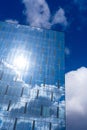 Architectural detail of the facade with multiple reflections of cloudy sky and the sun Royalty Free Stock Photo