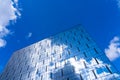 Architectural detail of the facade with multiple reflections of cloudy sky and the sun Royalty Free Stock Photo