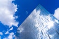 Architectural detail of the facade with multiple reflections of cloudy sky and the sun Royalty Free Stock Photo