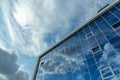 Architectural detail of the facade with multiple reflections of cloudy sky and the sun Royalty Free Stock Photo