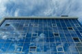 Architectural detail of the facade with multiple reflections of cloudy sky and the sun Royalty Free Stock Photo