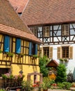 Architectural detail of historic half-timbered houses with flowers and wooden carriage in front