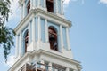 Architectural details - a bell tower with a bell, decor and stucco on a blue sky background. walking space, tracked architectural