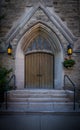 Architectural details - old wooden door with stained glass, entrance to the building with lanterns Royalty Free Stock Photo