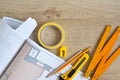 Architectural drawings and pencils, ruler, clerical knife, scotch tape on wooden background. Top view. Repair housing concept