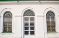 Architectural facade featuring arched windows and decorative ironwork on a white building exterior Royalty Free Stock Photo