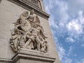 Architectural fragment of Arc de Triomphe du Carrousel, under sky with clouds in Paris.