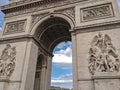 Architectural fragment of Arc de Triomphe du Carrousel, under sky with clouds in Paris.