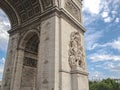 Architectural fragment of Arc de Triomphe du Carrousel, under sky with clouds in Paris.