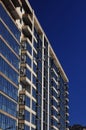 Architectural fragment of the facade of an apartment building, brick walls and glass balconies against the blue sky Royalty Free Stock Photo