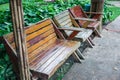 Architectural landscaped design wooden bench and chairs for lying your back near green grass ornamental garden in public park. Lif Royalty Free Stock Photo