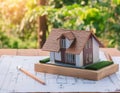 Architectural model of a house on blueprint with nature background