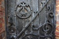 Architectural vintage background - old rusty black metal door with plates and aged metal door handle in the old red brick wall. Royalty Free Stock Photo