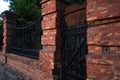 Architectural vintage background - old rusty black metal door with plates and aged metal door handle in the old red brick wall Royalty Free Stock Photo