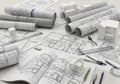 Architectural workspace featuring detailed blueprints and drawings spread across a light-colored Royalty Free Stock Photo