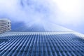 Architecture concept Modern skyscraper of glass and steel exterior seen from below on a foggy day Royalty Free Stock Photo