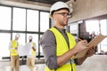 male architect in helmet with clipboard at office Royalty Free Stock Photo