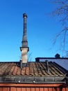 Close up of Prefabricated building roof with industrial black chimney under blue sky. Architecture and construction detail