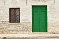 Architecture details from the Renaissance - green painted wooden door and window with a grate of a stone house in Kavarna city, Royalty Free Stock Photo