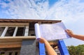 Architecture drawings in hand on big house building