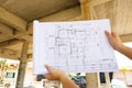 Architecture drawings in hand on house building background