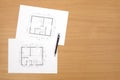 Architecture floor plan on paper is located on a table with a wood texture Royalty Free Stock Photo