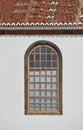 Architecture of a grey wall with an arched window outside. Exterior texture details of an old rustic residential