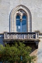 Architecture, historic arched window with balcony. Tree of oranges.