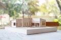 An architecture model with shop drawing paper and laptop on table in office with blur nature Royalty Free Stock Photo