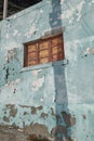 Architecture of an old blue wall with peeling paint outside. Exterior texture details of an old rustic residential build Royalty Free Stock Photo