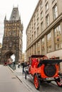 Architecture of Prague old town with red retro car on the street. Gunpowder tower