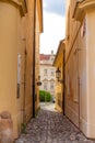 The architecture of the strago city of Prague. Old european streets, yellow low buildings and stone paving stones