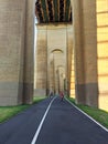 Archway corridor. Row of columns as a long tunnel with a road. Biker and jogger Royalty Free Stock Photo