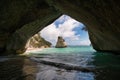 an archway in the ocean with a view of a rock