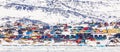 Arctic city center panorama with colorful Inuit houses on the rocky hills covered in snow with snow and mountain in the background Royalty Free Stock Photo