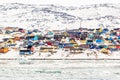 Arctic city center panorama with colorful Inuit houses on the rocky hills covered in snow with snow and mountain in the background Royalty Free Stock Photo