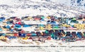 Arctic city center panorama with colorful Inuit houses on the rocky hills covered in snow with snow and mountain in the background Royalty Free Stock Photo