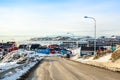 Arctic city center panorama with colorful Inuit houses on the rocky hills covered in snow with snow and mountain in the background Royalty Free Stock Photo