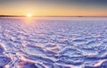 The Arctic cold landscape of icy lake at sunset with textural cracks and patterns on the ice. Royalty Free Stock Photo